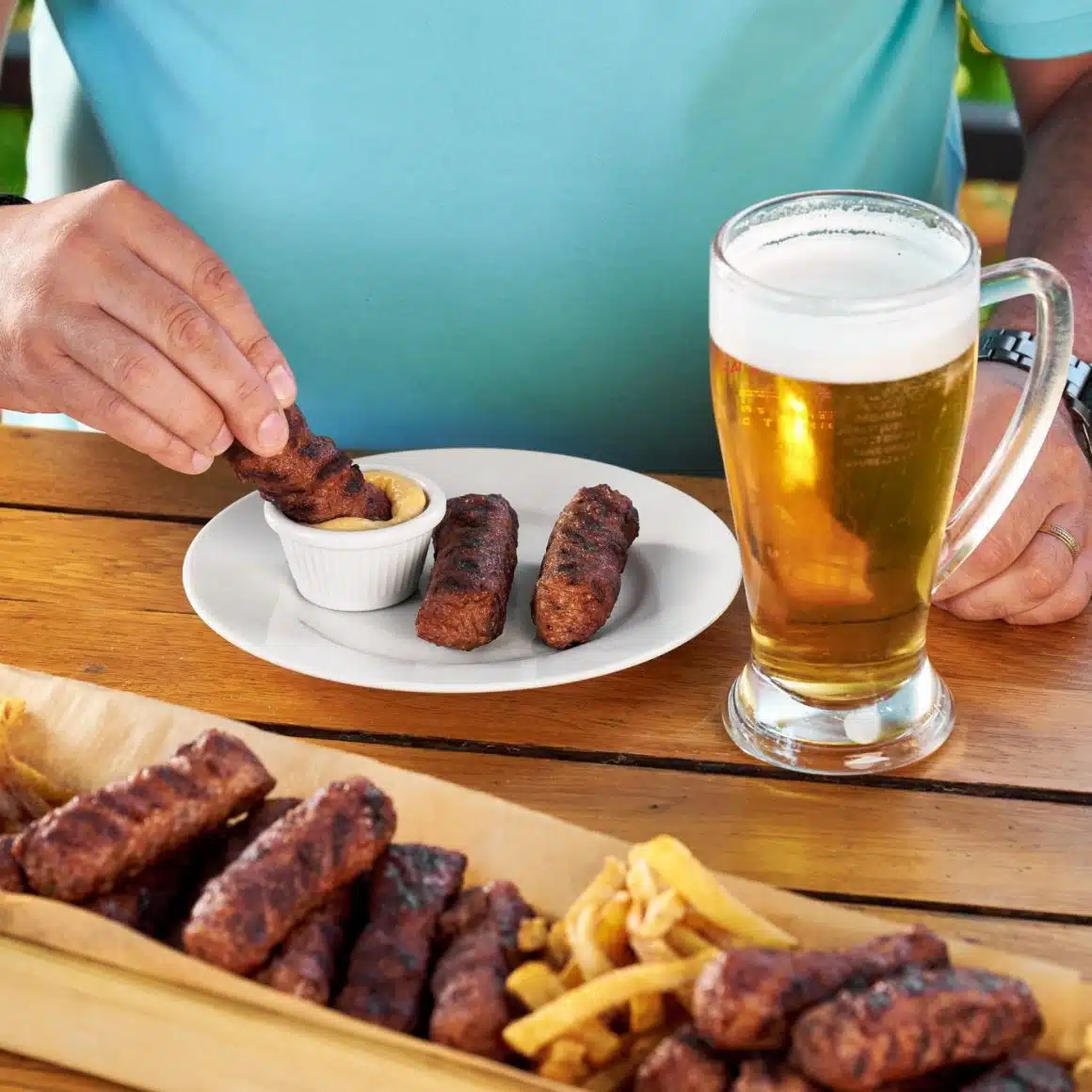 Romanians eating mici and drinking beer